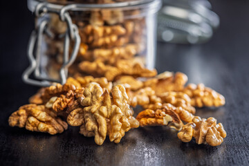 Peeled walnut kernels on black table.