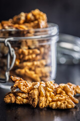 Peeled walnut kernels on black table.