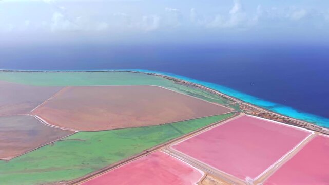 Aerial view of pink salt ponds and white salt mounds in Bonaire

