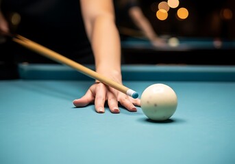 A focused view of a player s hand gripping a pool cue preparing to strike a white cue ball on a blue