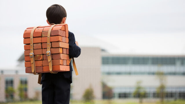 Child carrying a heavy brick backpack, concept of burden in education, metaphor for academic pressure, young student facing educational challenges, symbolic representation of school stress