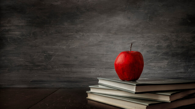 Horizontal color image of a red apple on a stack of books - Powered by Adobe