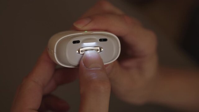 Close-up of man operating modern electronic nail file, carefully trimming fingernails for precise shaping, emphasizing personal care, hygiene and home manicure routine. Shooting in slow motion.