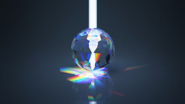 Close-up of faceted crystal sphere illuminated by vertical white light beam creating colorful refraction patterns on dark reflective surface
 - Powered by Adobe