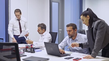 A diverse team of business coworkers collaborate on a project during a productive office meeting. They discuss important documents, analyze data on a laptop, and work together to achieve their goals. - Powered by Adobe