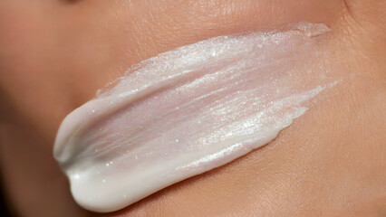 Pearlescent white cream smear on skin texture, shimmer makeup highlighter swatch, glowing moisturizer stroke macro closeup, for beauty, fashion, cosmetics, spa, facial.