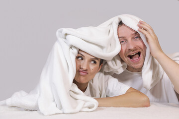 Lovely couple lying in a bed, happy smile looking to each other, people. Couple in love. Romance. Lovers. Photo. People