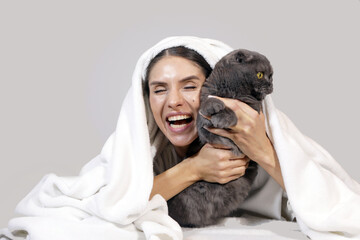 Close-up portrait of a beautiful cheerful young woman with a cute cat. Cat. Smiling woman face. Family. Happy day
