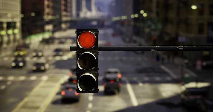A red traffic light hangs over a busy city intersection with cars waiting below. Tall buildings line the street, and sunlight casts shadows on the pavement, creating a lively atmosphere.