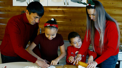 A family is baking Christmas cookies together in the kitchen