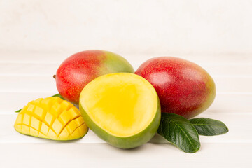 Fresh ripe mango with leaves on wooden table