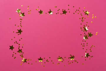 Golden star shape confetti on color background, top view