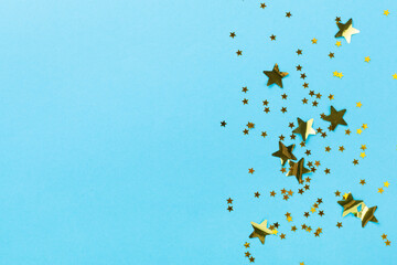 Golden star shape confetti on color background, top view