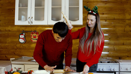 Family are decorating a Christmas cake in the kitchen