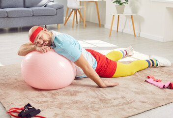 Funny and lazy or tired man is sleeping on the floor during a home workout training. Relaxation and the need for rest after a fitness session, adding a touch of humor to the gym environment.