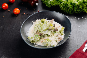 Spinach tagliatelle in creamy mushroom sauce with parmesan and microgreens, restaurant plating