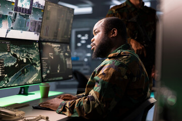 Army operative conducts tactical reconnaissance, utilizing equipment for data analysis and mission planning. Air defense forces agent looks at aerial map on screen, pinpointing targets