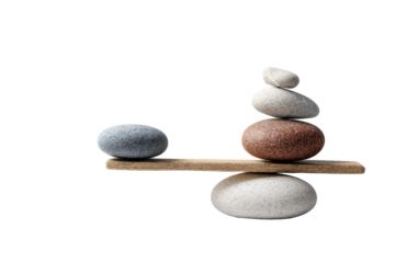 A wooden seesaw balanced with stacks of stones, one dark gray and the other light beige/brown