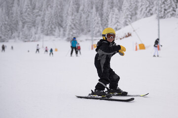 Young child learning skiing on a snowy slope