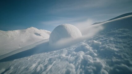 Snowball rolling down a snowy mountain gaining size and momentum symbolizing growth acceleration inevitability cascading force and natural winter energy in a simple dynamic scene