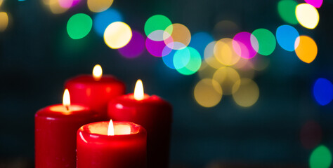 candles burning against holiday lights background
