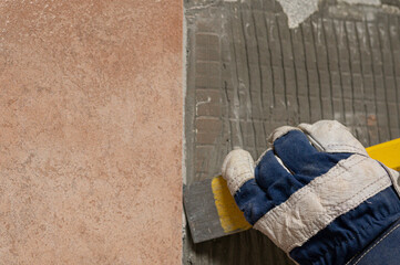 Denmark, november 2025, glove with chisel hammering tiles down