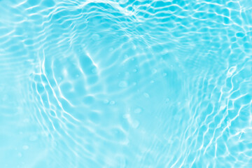 Blue water with ripples on the surface. Defocus blurred transparent blue colored clear calm water surface texture with splashes and bubbles. Water waves with shining pattern texture background.