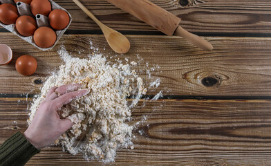 Step 4: A woman's hands knead the dough on a wooden table.