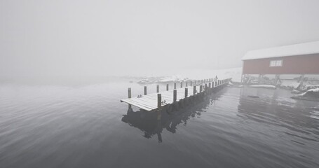A tranquil winter morning shows a wooden dock extending into still water, while a cozy cabin peeks through the fog. Snow blankets the surrounding landscape, creating a serene atmosphere. - Powered by Adobe