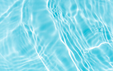 Blue water with ripples on the surface. Defocus blurred transparent blue colored clear calm water surface texture with splashes and bubbles. Water waves with shining pattern texture background.