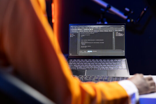 Person in home office looking at UI on laptop screen, typing and executing programming code. Coding application UI used by IT developer writing and testing code in modern workspace, close up shot