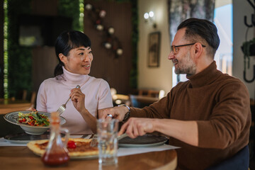 Mature multiracial couple enjoying lunch together at restaurant