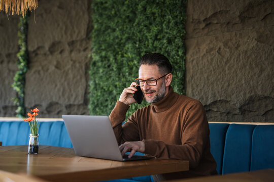 Confident man working remotely, talking on phone call