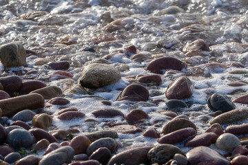 Pebble Beach with White Ocean Foam and Waves