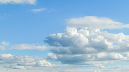 Fototapeta premium Beautiful fluffy clouds in a bright blue sky on a sunny day