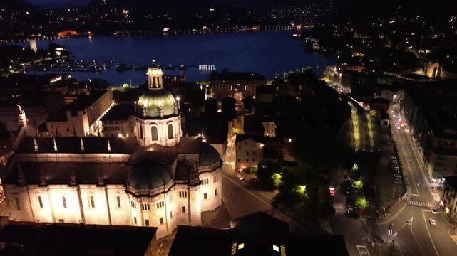 nocturnal aerial view of Como Cathedral illuminated with cinematic lights showcasing the intricate details of the dome from above 8