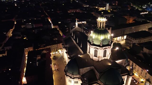 nocturnal aerial view of Como Cathedral illuminated with cinematic lights showcasing the intricate details of the dome from above 6