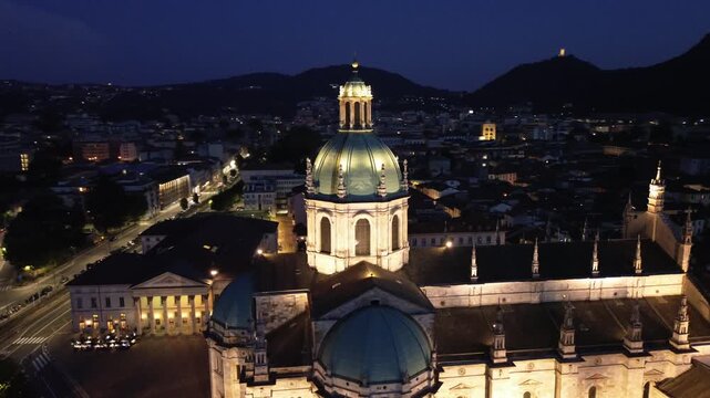 nocturnal aerial view of Como Cathedral illuminated with cinematic lights showcasing the intricate details of the dome from above 3