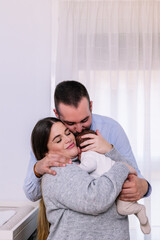 Fototapeta premium New parents embracing adorable newborn baby with love