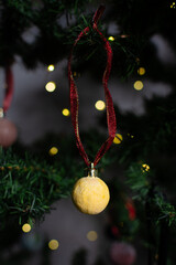 close up of Christmas ornaments on a green christmas tree, sparkly textured christmas tree baubles on artificial tree