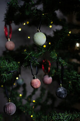 close up of Christmas ornaments on a green christmas tree, sparkly textured christmas tree baubles on artificial tree