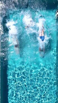 Aerial overhead view of a happy family jumping together in the pool as a summer travel concept with copy space
