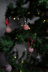 close up of Christmas ornaments on a green christmas tree, sparkly textured christmas tree baubles on artificial tree