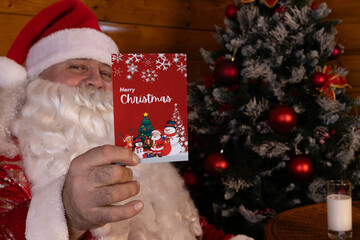 Man in Santa suit holding a Christmas card