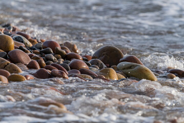 Crashing Waves Sending White Foam Through Beach Rocks