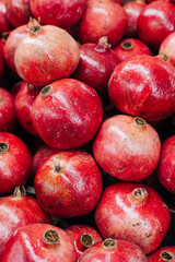 Fresh pomegranates stacked in a vibrant display at a local market during the afternoon