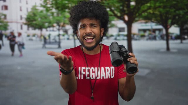 Lifeguard man with afro hairstyle holding binoculars, expressing frustration on a city street with trees and buildings in the background.