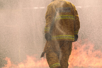 Firefighter facing intense flames with courage during emergency response.