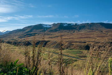 Icelandic landscape with mountains and meadow in the foreground.