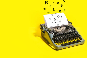Vintage typewriter on yellow background
